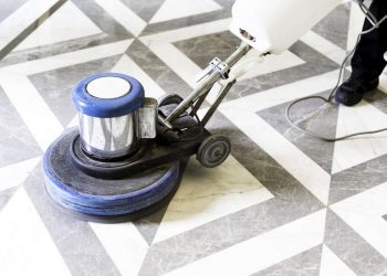 man polishing marble floor in modern office building